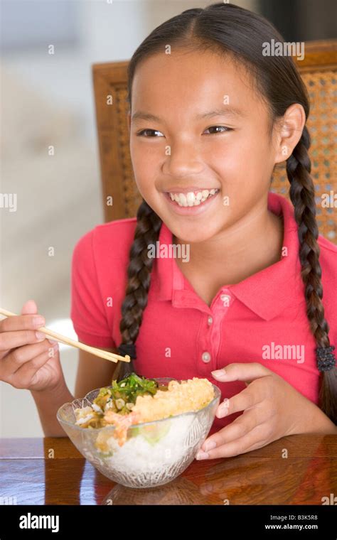 Young girl in dining room eating Chinese food smiling Stock Photo - Alamy