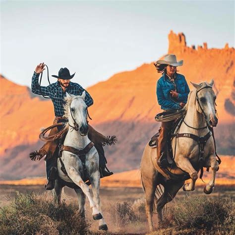 two men are riding horses in the desert