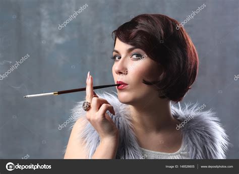 Woman smoking with cigarette holder — Stock Photo © belchonock #148526605