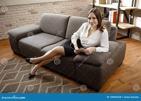 Nice Young Businesswoman Sit on Sofa and Pose on Camera. Model Smile. Alone in Room. Stock Photo ...