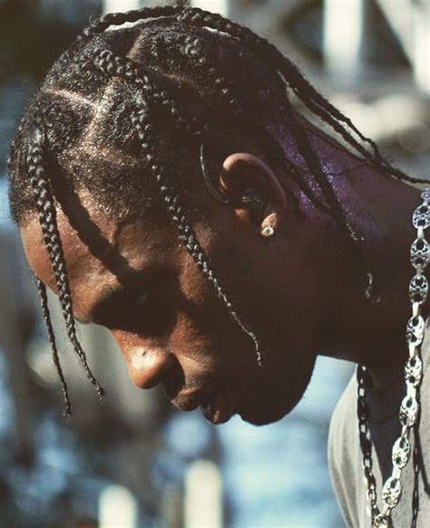 a man with dreadlocks is looking down at his cell phone while wearing a ...