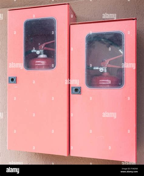 Two fire extinguishers in their lockers red Stock Photo - Alamy