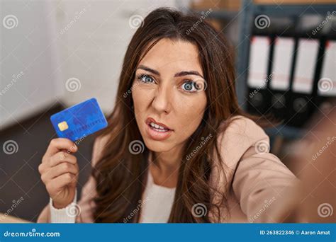 Young Brunette Woman Working at Small Business Ecommerce Holding Credit Card Clueless and ...