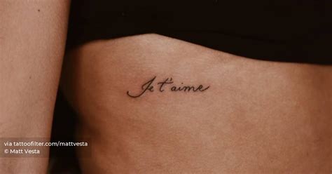 "Je t'aime" lettering tattoo handwritten on the rib.