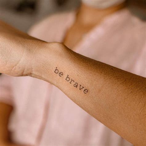 "Be brave" lettering tattoo on the wrist.