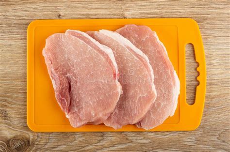 Pieces of Raw Pork Schnitzel on Cutting Board on Wooden Table. Top View Stock Image - Image of ...