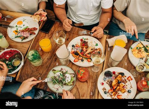 Group of people eating breakfast or brunch at table in cafe Stock Photo ...