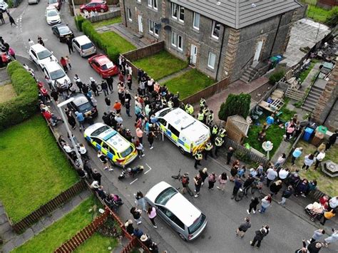 Angry Fife mob chant ‘beast’ and throw eggs at house as man led away to safety by cops after ...