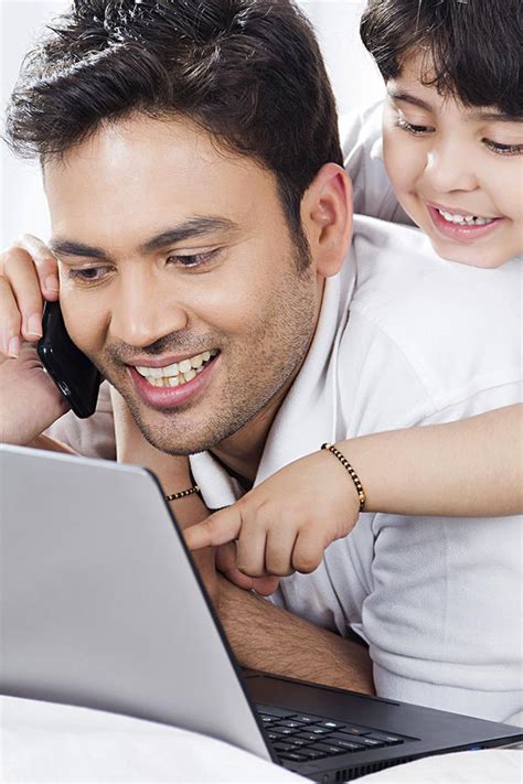 Happy Father And Kid-Son Looking-at Laptop Screen Pointing in-Bedroom At-home