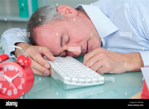 man sleeping on his desk in bright modern office Stock Photo - Alamy