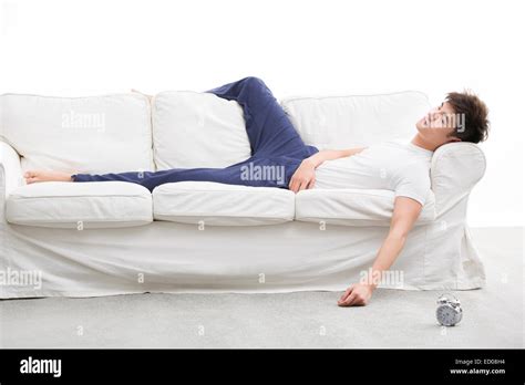 Young man sleeping on couch Stock Photo - Alamy