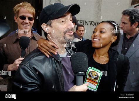 Radio personalities Gregg "Opie" Hughes (L) looks on as Anthony Cumia (C) greets Francine Pierre ...