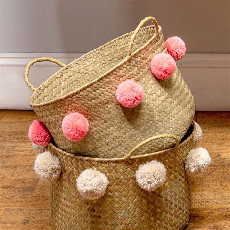 This charming seagrass basket with a coral pom pom works perfectly as a storage solution in ...