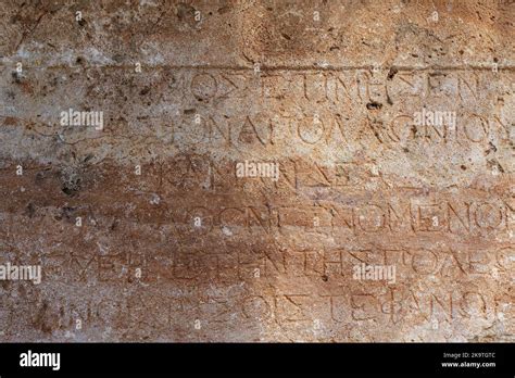 Ancient Greek antique text and inscriptions on the stone wall of the temple. Ancient Greek ...