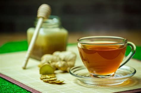 Premium Photo | Ginger juice in a clear cup and honey jar placed beside with measuring tape.