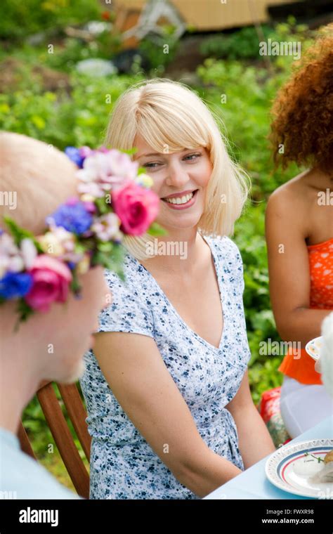 Young people sitting outside at picnic table Stock Photo - Alamy