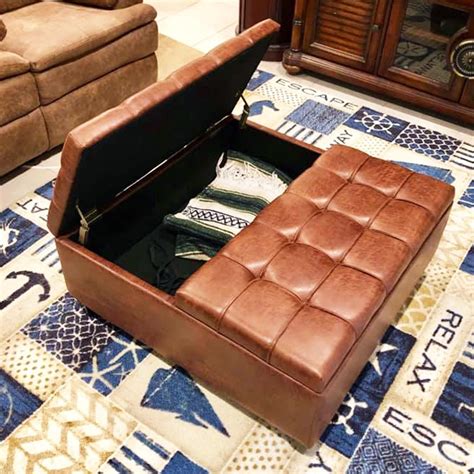 a brown leather ottoman sitting on top of a rug
