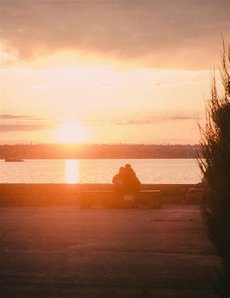 Silhouette of Couple Sitting on Bench during Sunset · Free Stock Photo