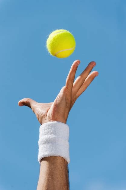 Premium Photo | Serving tennis ball. Close-up of male hand in wristband ...