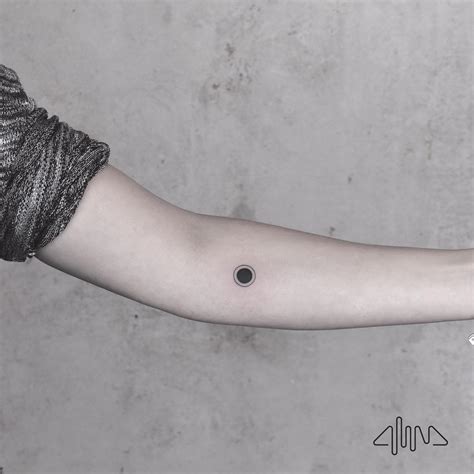 A small black hole by @alinabaertattoo - Tattoogrid.net