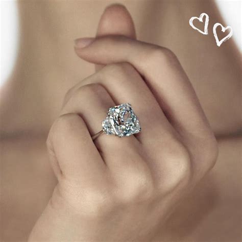 a woman's hand holding a diamond ring