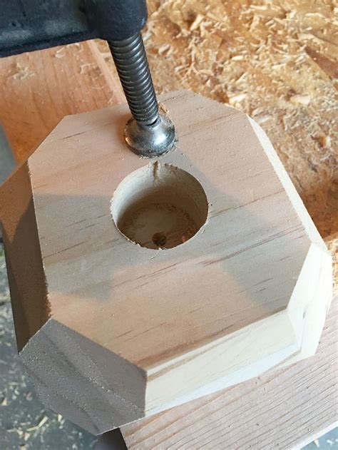 a piece of wood is being worked on with a small drill bit in the center