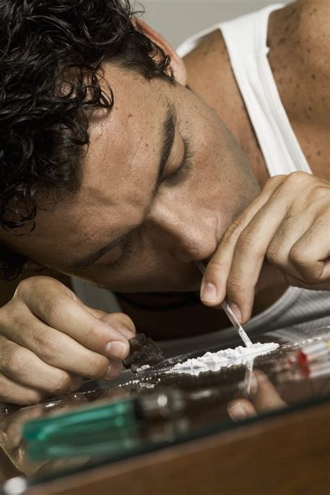 Close-up of a man inhaling cocaine with a glass straw | Clearbrook Treatment Centers