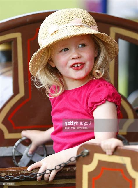 Savannah Phillips (accompanied by her parents Peter and Autumn Phillips) rides a merry go round ...