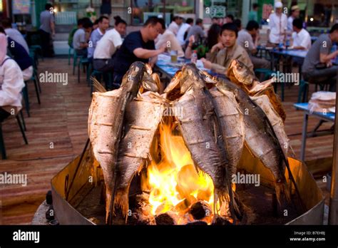 Grilling fish at the night market in Urumqi in Xinjiang in China Stock ...