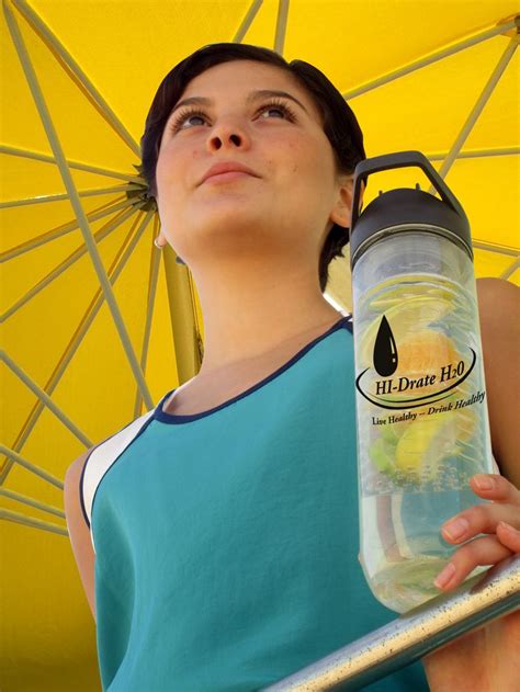 a woman is holding a water bottle under an umbrella