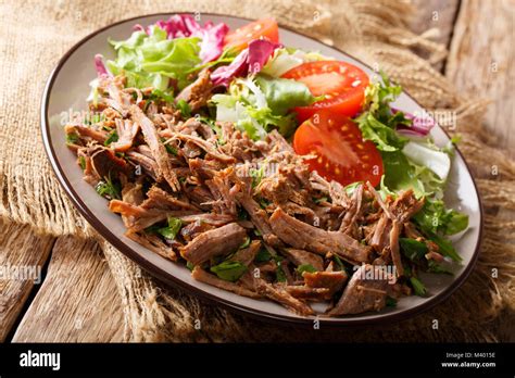 Healthy lunch: tender pulled beef with vegetable salad close-up on a ...