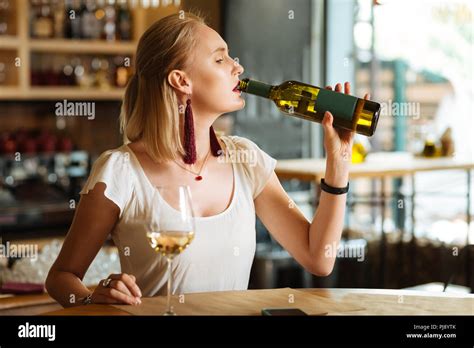 Nice sad woman drinking wine from the bottle Stock Photo - Alamy