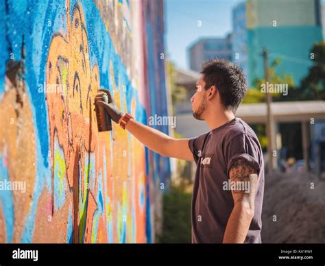 Handsome Talented Young Boy making a colorful graffiti with aerosol ...