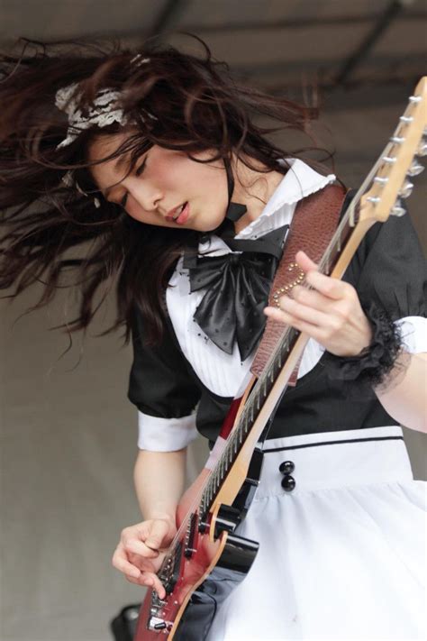 a woman with long hair playing an electric guitar at a music festival ...