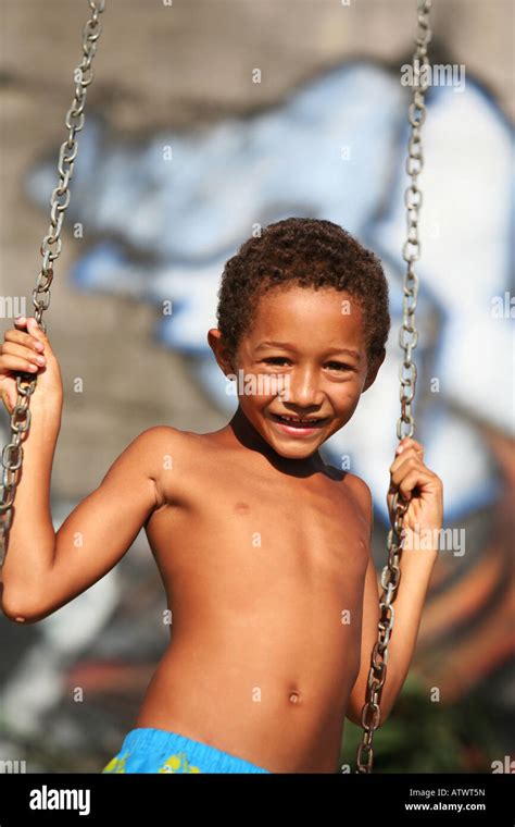 Los niños juegan en el columpio en tugurios en las favelas de Río de Janeiro con graffiti ...