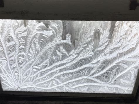 Frost patterns on my window emanate from an imperfection on the glass. : mildlyinteresting