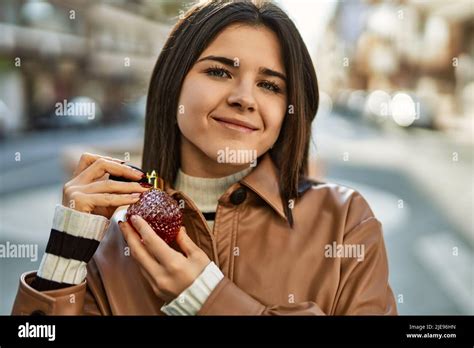 Young beautiful brunette woman smiling happy applying fragance from luxury perfume Stock Photo ...