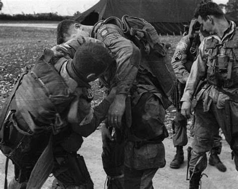 Prior to their D-day jump into Normandy, members of the 82nd Airborne check over their gear ...