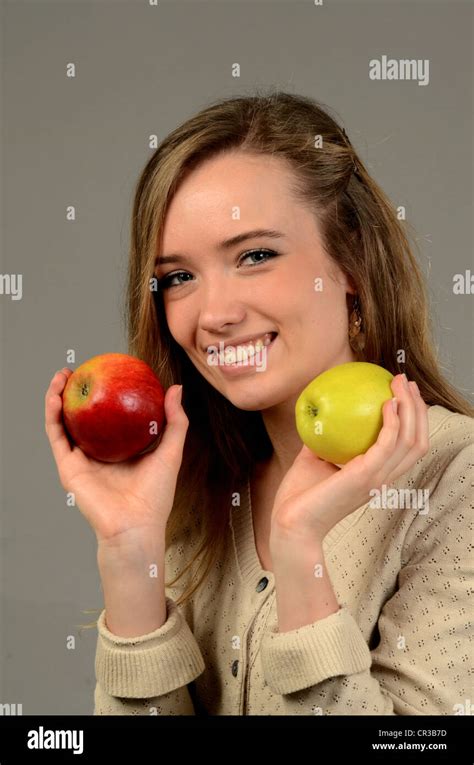 Young woman with two apples, one red and one green, in her hands Stock Photo - Alamy