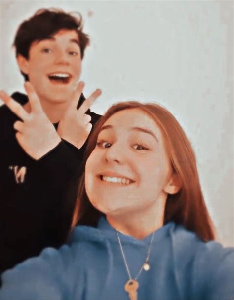 two people making the peace sign with their hands and one person smiling at the camera