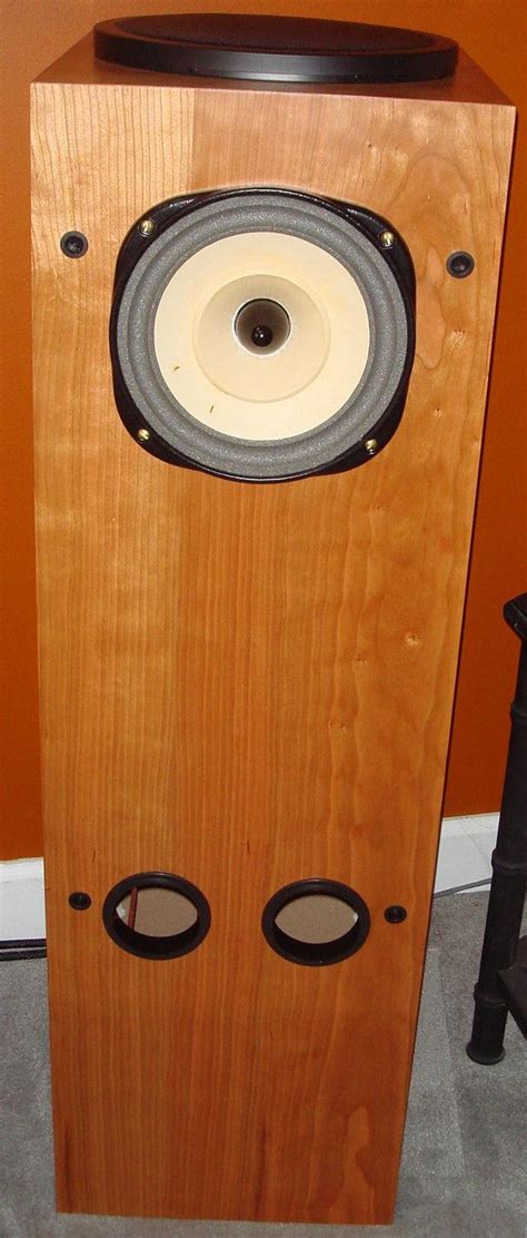 a wooden speaker sitting on top of a carpeted floor