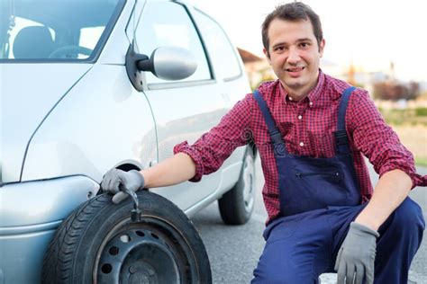 Man Changing a Flat Tire on the Side of the Road Stock Image - Image of assistance, safety ...