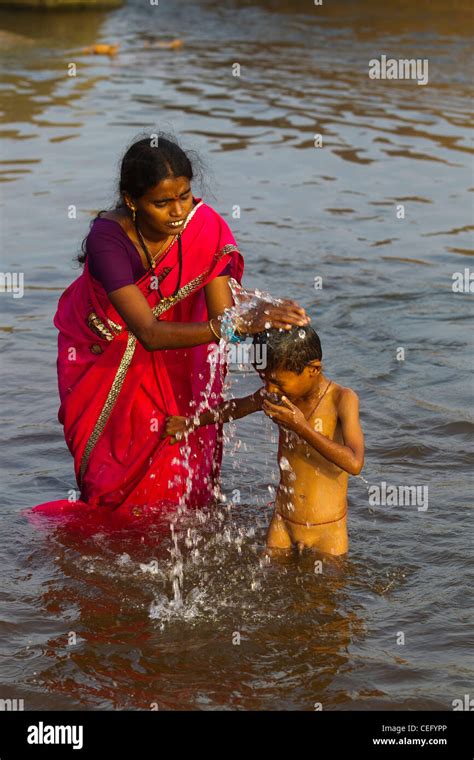 Indian mother bathing his son on the waters of Tungabhadra river, Hampi ...