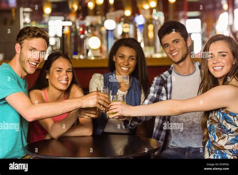 Portrait of happy friends toasting with drink and beer Stock Photo - Alamy