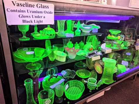 a display case filled with lots of green glassware and other items in ...