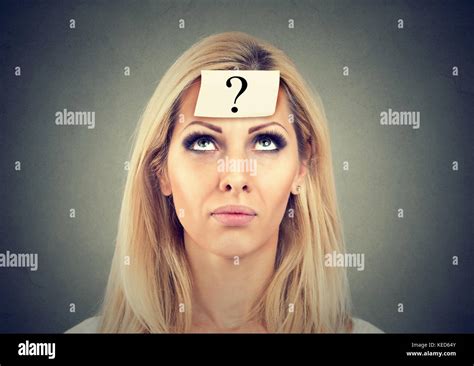 thinking woman with question mark looking up isolated on gray wall background Stock Photo - Alamy