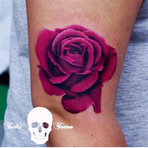 a woman's arm with a rose tattoo on it and a skull in the background