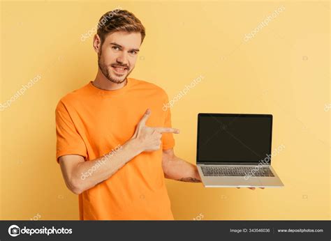 Cheerful Young Man Pointing Finger Laptop Blank Screen Yellow Background Stock Photo by ...