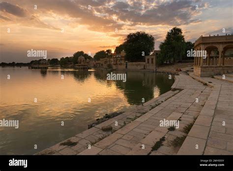 Beautiful sunset at Gadisar lake, Jaisalmer, Rajasthan, India. Setting sun and colorful clouds ...