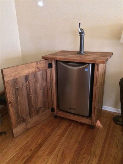 a wooden cabinet with a metal dishwasher in it and a door open on the side